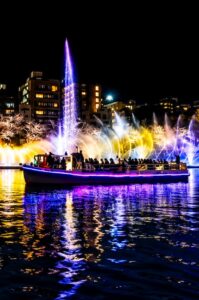 Colorful OSAKA River Fantasy fountains reflecting across the Okawa as a sightseeing boat passes the illuminated nighttime display.