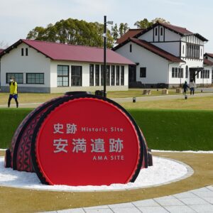 Ama Site Park in Takatsuki, Osaka, with its distinctive red archaeological park sign, green lawns and historic-style buildings.